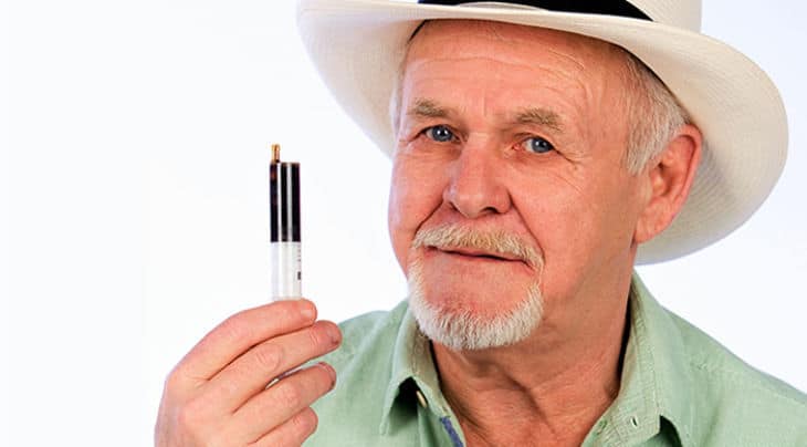 a man in a white hat holding a cigarette.