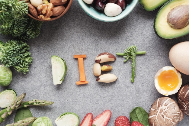 the word diet spelled out in letters surrounded by fruits and vegetables.