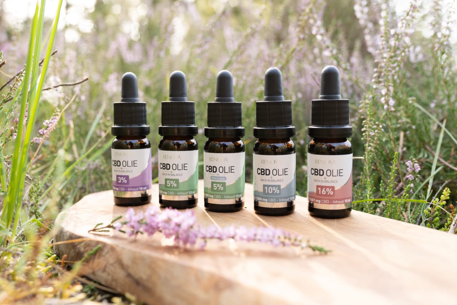 a group of bottles of essential oils sitting on top of a wooden table.